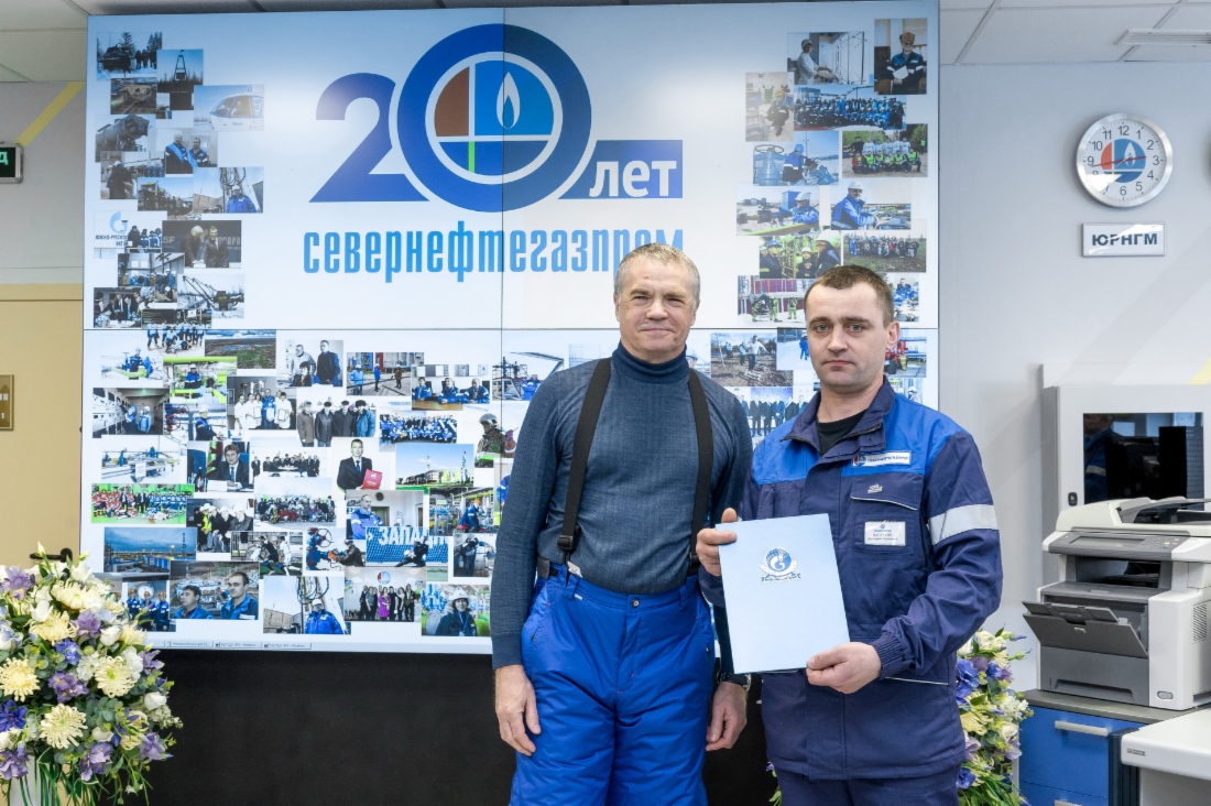 Alexander Medvedev (left), Deputy Chairman of Gazprom Management Committee, Chairman of Board of Directors of Severneftegazprom, handing note of acknowledgement to Dmitry Nastasyak (right), 4th-grade oil and gas production operator of gas production service