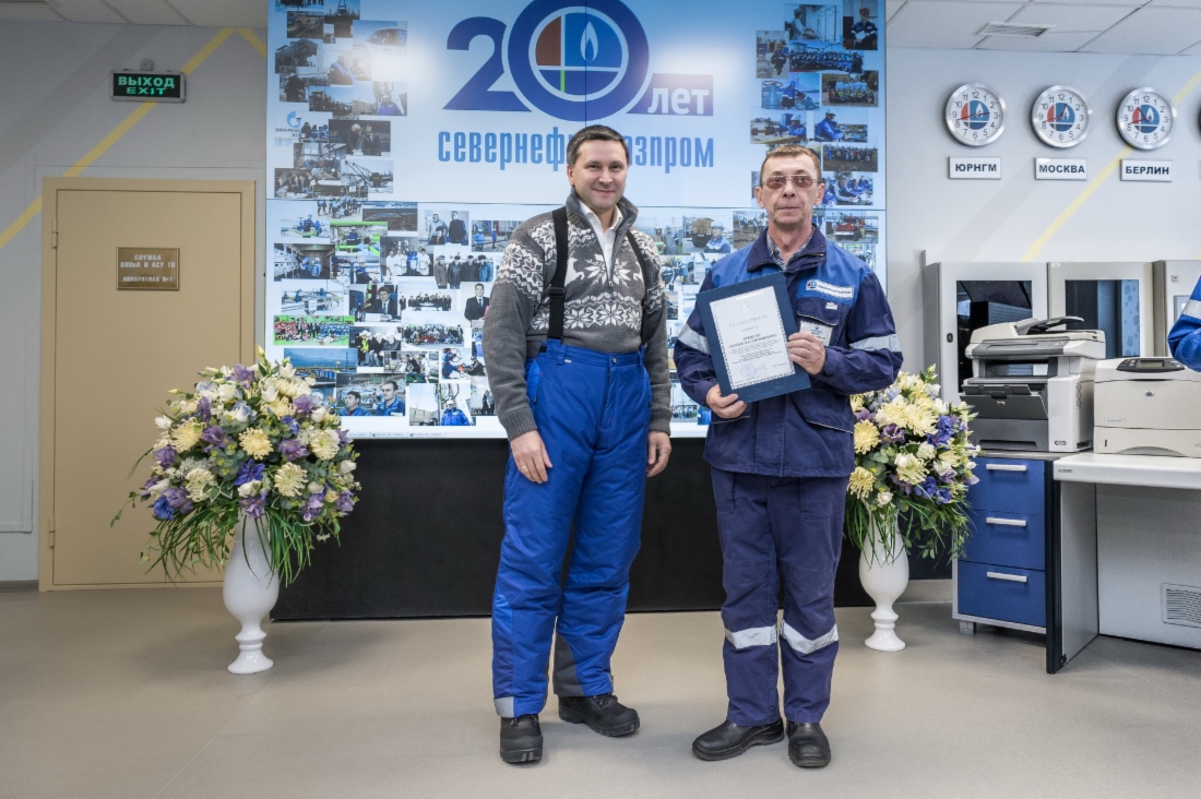 Dmitry Kobylkin (left), Governor of Yamal-Nenets Autonomous Area, handing note of acknowledgement to Sergey Kryukov (right), 6th-grade turner of mechanical and repair service